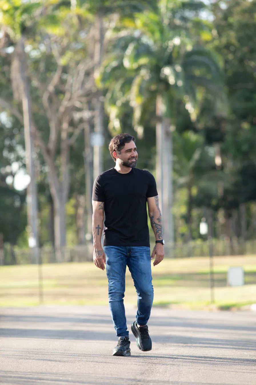 Ninho Testoni em caminhada ao ar livre, camiseta preta